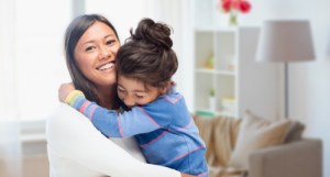 A woman smiling while holding a child
