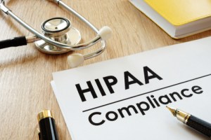 A form that reads HIPAA Compliance next to a stethoscope, notebook and a coupe pens