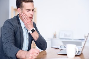 A man holding his jaw in pain