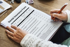 A person filling out a dental insurance form