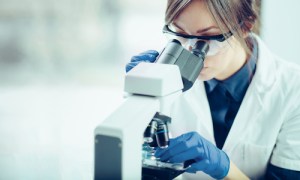 A woman looking into a microscope